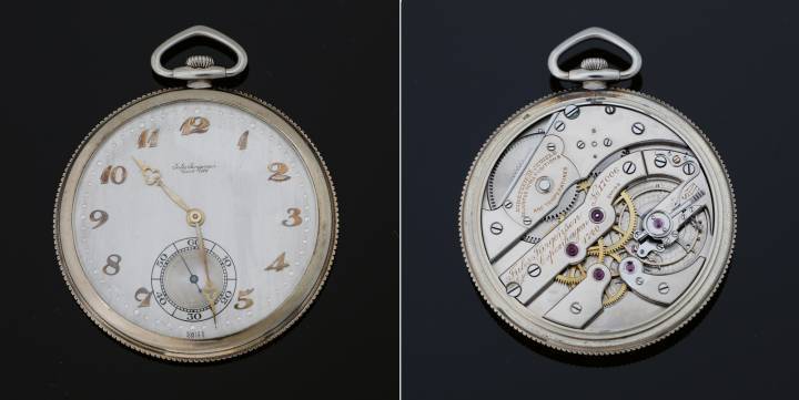 Reloj de bolsillo Jules Jürgensen del año 1926, número 17006. Caja de oro blanco de 18 quilates con borde estriado. Movimiento de 16,5 líneas con escape de palanca. Volante bimetálico con regulador de ajuste fino, que presenta una cola a medida en el resorte. Esfera fabricada en plata maciza con acabado cepillado y números Breguet dorados. Agujas de oro amarillo.